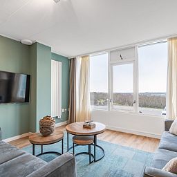 Helle Sitzecke im Apartment Juliana 124 Eilandzicht, De Koog, Texel mit bequemen Sofas und Aussicht.