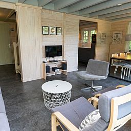 Gezellige binnenruimte van Het Boshuis, Vakantiepark Het Oude Dijkje in De Koog, Texel, met comfortabele zitruimte.