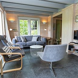 Stijlvolle woonkamer in Het Boshuis, Vakantiepark Het Oude Dijkje, De Koog, Texel, omgeven door natuur.