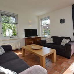 Gemuetliches Wohnzimmer des Ferienhauses 7G in De Koog, Texel mit bequemen Sofas und viel Tageslicht.