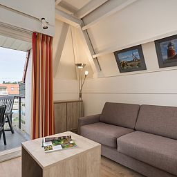 Gezellige woonkamer van C Appartement Comfort 4 in De Koog, Texel met balkon en uitzicht op de Waddeneilanden.