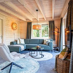 Gezellige woonkamer van De Verleegen Hoek vakantiehuis in De Koog Texel met houten interieur.