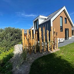 Vakantiewoning Duinvilla Wellness 5 in De Koog, Texel, met groene tuin en houten omheining.