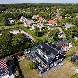 Luftaufnahme des Ferienhauses Residence Rustiek in De Koog, Texel, mit den umliegenden Haeusern