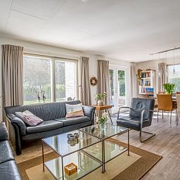 Heller Wohnbereich im Ferienhaus Kamperfoelie 91, De Koog, Texel, mit Essecke und geraeumiger Sitzecke.