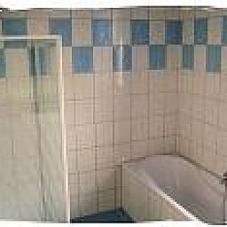 Modernes Badezimmer mit Dusche und Badewanne im Ferienhaus De Koog, Texel auf den Waddeninseln.