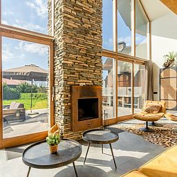 Gezellige woonkamer met open haard in Vakantiehuisje in De Koog, Texel, omringd door natuur.