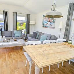 Gezellige woonkamer in Chalet Bregkoog 215 Zandhuisjes, Chaletpark Bregkoog, De Koog, Texel met comfortabele banken en houten vloer.