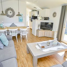 Lichte binnenruimte van Chalet Bregkoog 215 Zandhuisjes op Chaletpark Bregkoog, De Koog, Texel met open keuken en eetgedeelte.