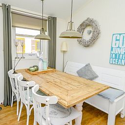 Eethoek in Chalet Bregkoog 215 Zandhuisjes, Chaletpark Bregkoog, De Koog, Texel met houten tafel en stijlvolle stoelen.