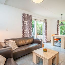 Moderne leefruimte in Huisje in De Waal, Texel met openslaande deuren naar het terras.