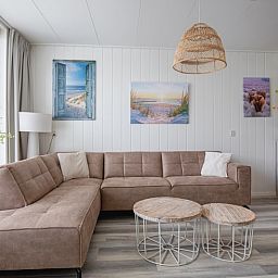 Gemuetliches Wohnzimmer von Schoonoord in Den Burg, Texel mit bequemem Sofa und Dekoration.