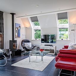 Moderne woonkamer van Uit Zicht in Den Burg, Texel met comfortabele zithoek.