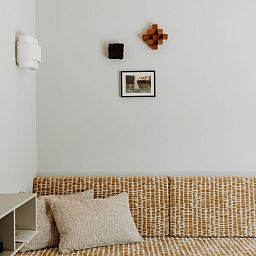 Stilvolle Wanddekoration und bequemes Sofa in der Luxuswohnung 4p, Den Burg, Texel.