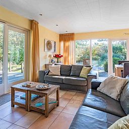 Lichte woonkamer in Huisje in Den Burg, Texel met toegang tot het terras en uitzicht op de natuur.