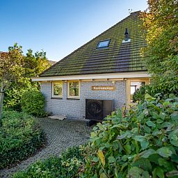 Vooraanzicht van Korenmolen vakantiehuis in Den Burg, Texel met weelderige tuin.