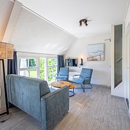 Gemuetliches Wohnzimmer des Appartements Gouden Reaal 25 in Den Hoorn Texel mit bequemen Sitzgelegenheiten.