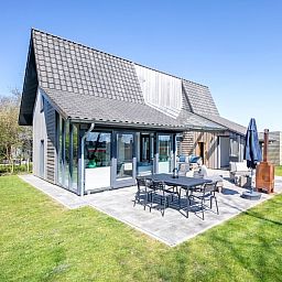 Uitzicht op TexelZon vakantiehuis in Den Hoorn met zonnig terras en tuin.
