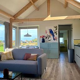 Gemuetliches Wohnzimmer des Ferienhauses in Den Hoorn, Texel, mit viel natuerlichem Licht.