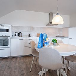 Moderne Kueche im Ferienhaus Grietje, Den Hoorn, Texel mit Esstisch und stilvollen Geraeten.