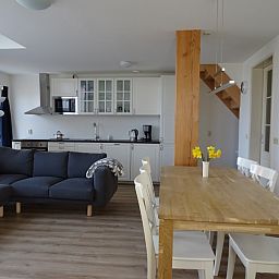 Moderne Kueche und Esszimmer in De Dors Ferienhaus Den Hoorn Texel fuer gemuetliches Beisammensein.