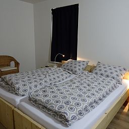 Gemuetliches Schlafzimmer im De Dors Ferienhaus Den Hoorn Texel mit Holzmoebeln.