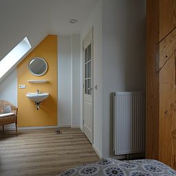 Stilvolle Ecke mit Waschbecken in De Dors Ferienhaus Den Hoorn Texel mit Holzdetails.