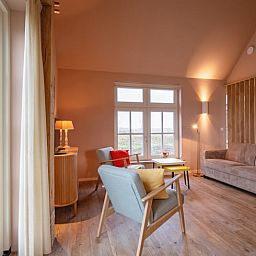 Gezellige woonkamer van Huisje in Den Hoorn, Texel, met comfortabele zitruimte en uitzicht op de natuur van de Waddeneilanden.