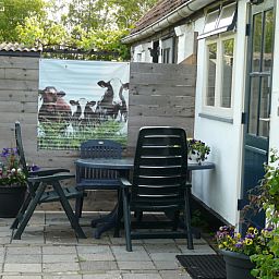 Aussenterrasse von De Viersprong in Oosterend, Texel mit Sitzgelegenheit und Blumen auf den Watteninseln.