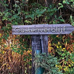 Sonniger Aussenbereich des Ferienhauses in Oosterend, Texel, mit Terrasse und Sitzgelegenheiten.