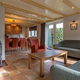 Open keuken en eetkamer in Gouden Rijder vakantiehuis, Oosterend, Texel, met een houtkachel voor extra sfeer.