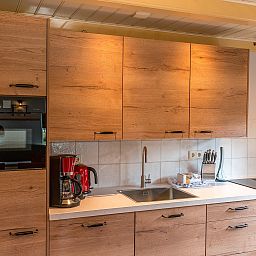 Moderne keuken in Gouden Rijder vakantiehuis, Oosterend, Texel, met houten kasten en moderne apparatuur.