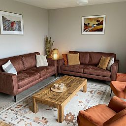 Eetruimte in Type II - nr. 47 Koolmees, vakantiehuis Oosterend, Texel met houten tafel en uitzicht op tuin.