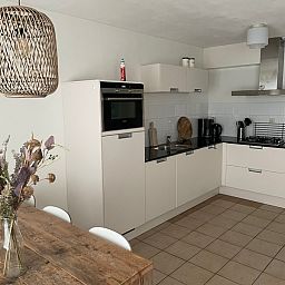 Stijlvolle badkamer in Type II - nr. 47 Koolmees, vakantiehuis Oosterend, Texel met witte tegels en douche.