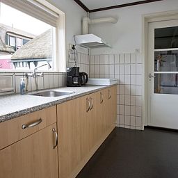 Moderne keuken van Hoe bestaat het vakantiehuis in Oosterend, Texel met functionele apparatuur.