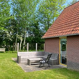 Cozy terrace at Type I - No. 89 Lark, vacation home in Oosterend, Texel, overlooking lush gardens.