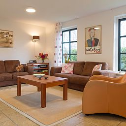 Gemuetliches Wohnzimmer in Typ III - Nr. 21B Fasan, Ferienhaus Oosterend Texel, mit bequemen Sofas und warmen Moebeln.