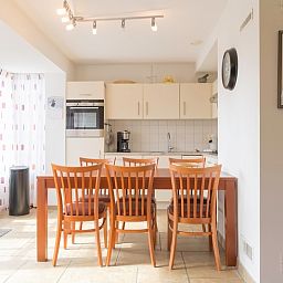 Essecke in Typ III - Nr. 21B Fasan, Ferienhaus Texel, mit Holztisch und moderner Kuecheneinrichtung.