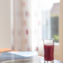 Entspannen Sie sich in Typ III - Nr. 21B Fasan, Ferienhaus Oosterend Texel, bei einem Glas Saft und Gartenblick.