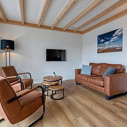 Stylish sitting area in Apartment C, Oudeschild, with comfortable leather chairs and sofa.
