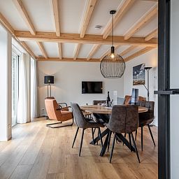 Spacious dining room in Apartment C, Texel, with wooden dining table and lots of natural light.