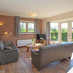 Gemuetliches Wohnzimmer im Ferienhaus 8690 - Junier - Huisman, Zuid-Eierland, Texel, mit viel Tageslicht und Blick auf den Garten.