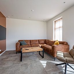Gemuetliches Wohnzimmer im Ferienhaus De Zuidbunder auf Texel mit bequemem Sofa und moderner Einrichtung.