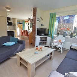 Zonnige woonkamer in Vakantiehuis De Nagtegaal 15, De Wulk, De Dennen, Texel, met uitzicht op de tuin.