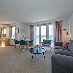 Lichte woonkamer van Huisje 7 in De Dennen, Texel met comfortabele zithoek en uitzicht op de natuur van de Waddeneilanden.