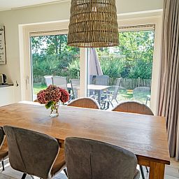 Essecke im Ferienhaus de Parel 150 in De Dennen, Texel mit Blick auf die gruene Umgebung.