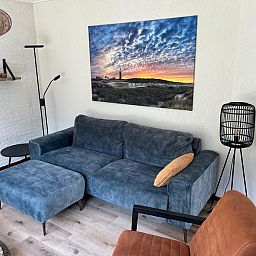 Gezellige woonkamer van vakantiehuis de Parel 162 in Bungalowpark de Parel, De Dennen, Texel met comfortabele bank.