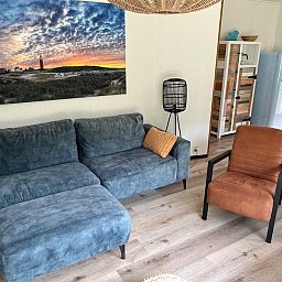 Stijlvolle zithoek in vakantiehuis de Parel 162, Bungalowpark de Parel, De Dennen, Texel met kunst aan de muur.
