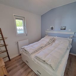 Slaapkamer met tweepersoonsbed in Vakantiepark de Bremakker, Bosveld 135, De Dennen, Texel, voor een rustgevende nacht.
