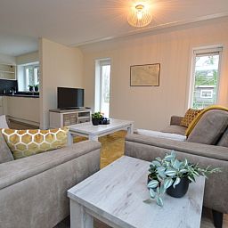 Gemuetliches Wohnzimmer des Ferienhauses De Nagtegaal 23 in De Dennen Texel mit bequemer Sitzecke.